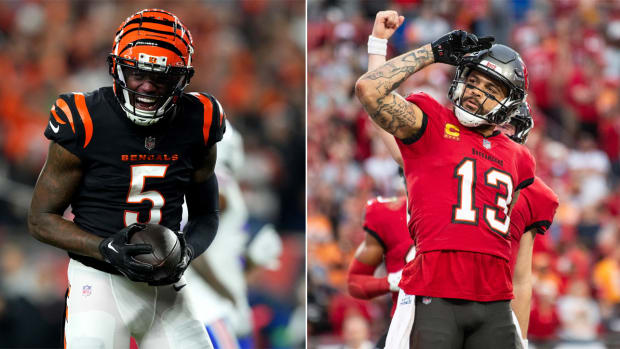Tee Higgins yells in celebration holding the football; Mike Evans salutes